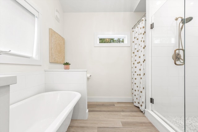 48 Osceola St, Saint Augustine, FL 32084 - bathroom featuring wood finished floors, a shower stall, and a freestanding tub