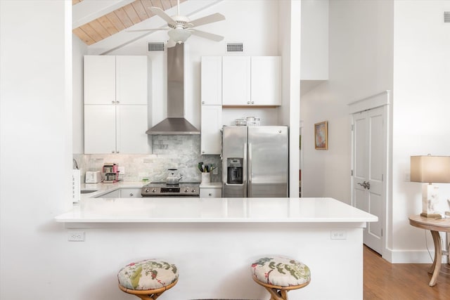 48 Osceola St, Saint Augustine, FL 32084 - kitchen featuring a peninsula, high vaulted ceiling, wall chimney exhaust hood, tasteful backsplash, and appliances with stainless steel finishes