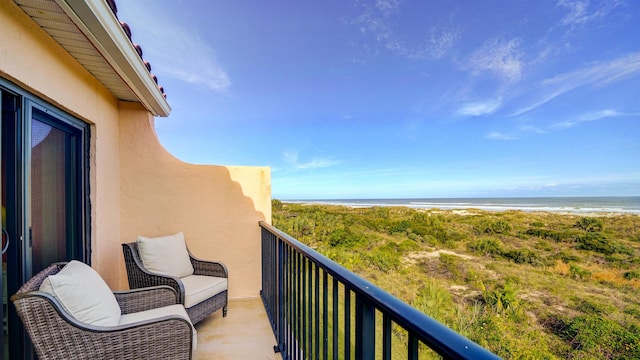 balcony with a water view and a beach view