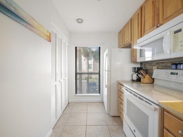 kitchen with light tile patterned floors, white appliances, and backsplash