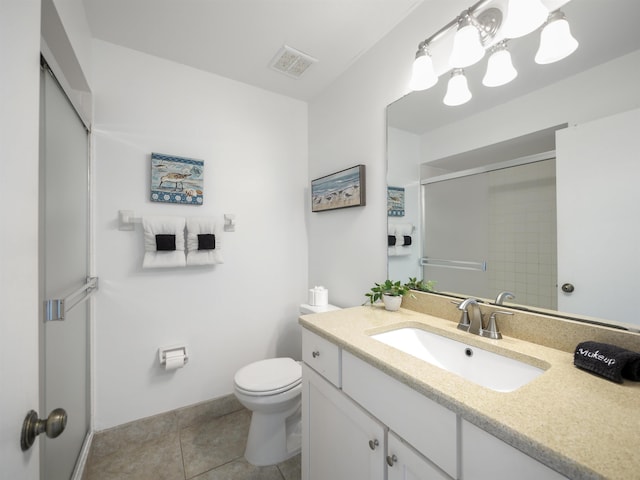 bathroom with tile patterned flooring, vanity, toilet, and a shower with shower door