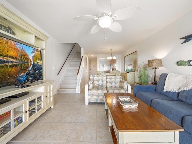 tiled living room featuring ceiling fan with notable chandelier