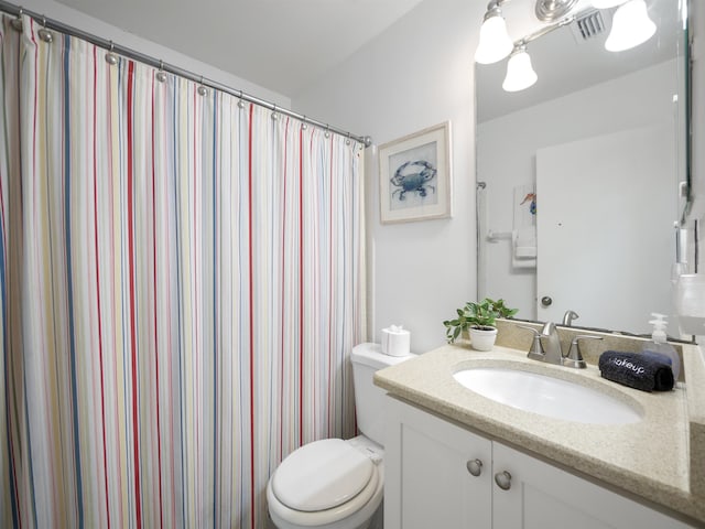 bathroom with walk in shower, vanity, and toilet