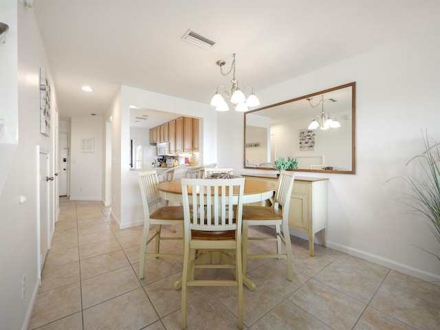 tiled dining area featuring an inviting chandelier