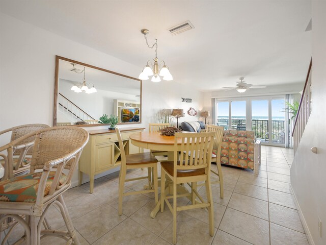 dining space with ceiling fan with notable chandelier and light tile patterned flooring