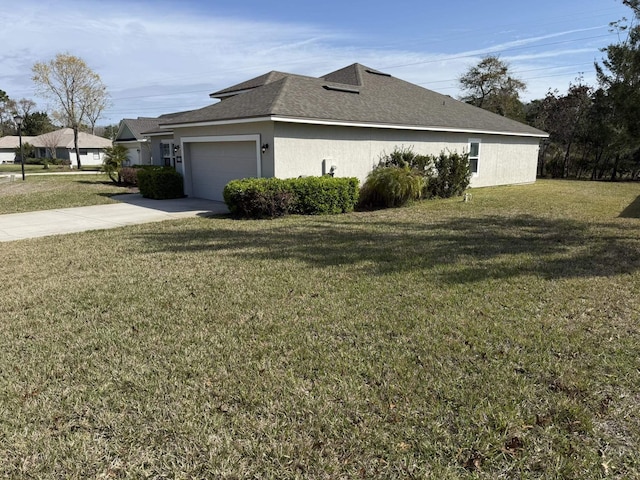 view of side of home featuring stucco siding, a shingled roof, a lawn, an attached garage, and driveway