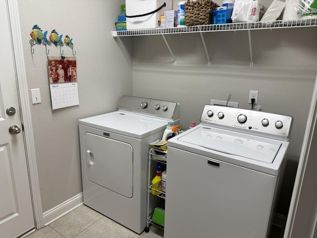 laundry area with laundry area, light tile patterned floors, baseboards, and washer and clothes dryer