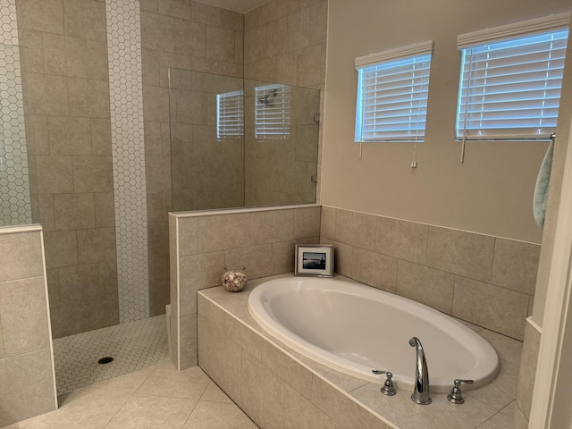 full bathroom featuring a walk in shower, a bath, and tile patterned floors