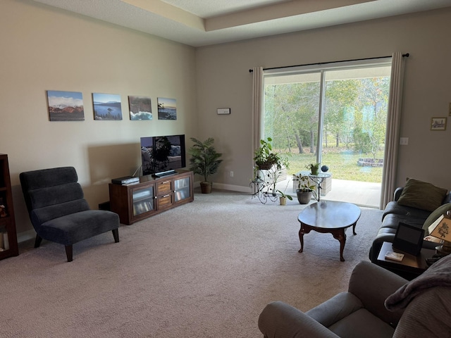 carpeted living room featuring baseboards