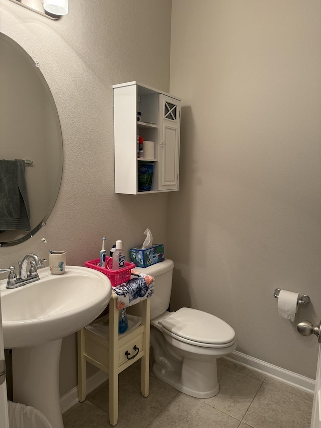 bathroom featuring baseboards, toilet, and tile patterned floors