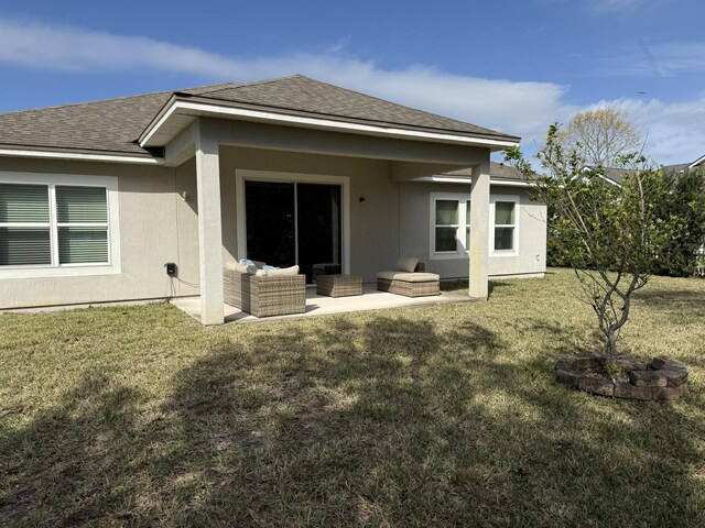 back of house with a patio area, an outdoor living space, a lawn, and roof with shingles