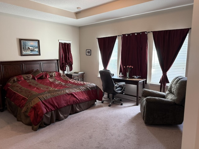 carpeted bedroom with a textured ceiling and multiple windows