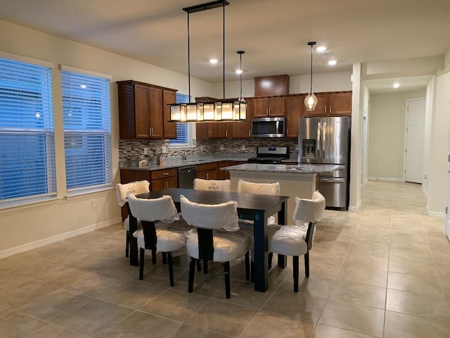 46 Curved Bay Trl, Ponte Vedra, FL 32081 - kitchen with backsplash, a kitchen island, hanging light fixtures, stainless steel appliances, and baseboards