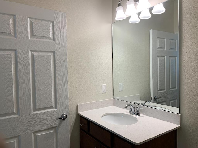 46 Curved Bay Trl, Ponte Vedra, FL 32081 - bathroom featuring a textured wall, an inviting chandelier, and vanity
