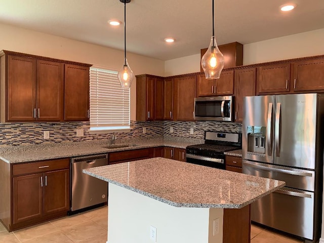 46 Curved Bay Trl, Ponte Vedra, FL 32081 - kitchen with decorative backsplash, a kitchen island, appliances with stainless steel finishes, light stone counters, and pendant lighting