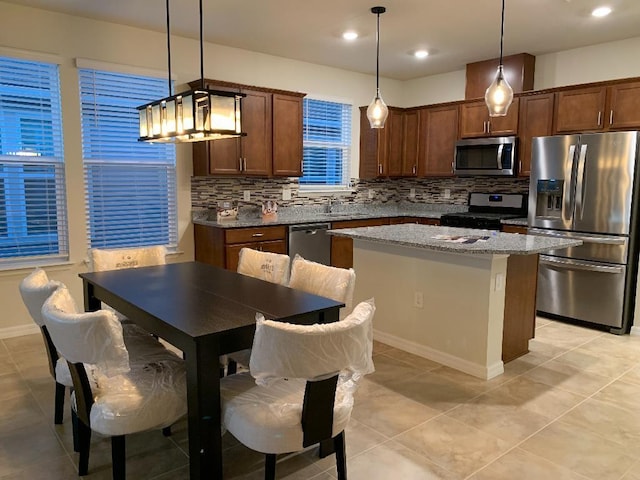 46 Curved Bay Trl, Ponte Vedra, FL 32081 - kitchen with tasteful backsplash, decorative light fixtures, stainless steel appliances, a center island, and light stone countertops