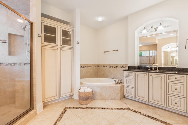 bathroom featuring plus walk in shower, vanity, and tile patterned flooring