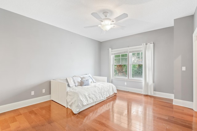 bedroom featuring ceiling fan, hardwood / wood-style floors, and a textured ceiling