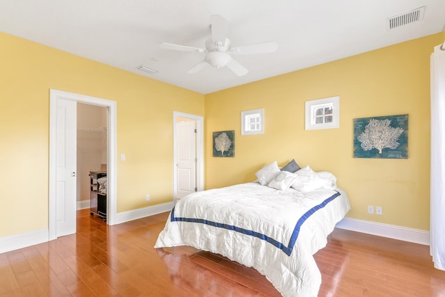 bedroom featuring hardwood / wood-style floors, a closet, a spacious closet, and ceiling fan