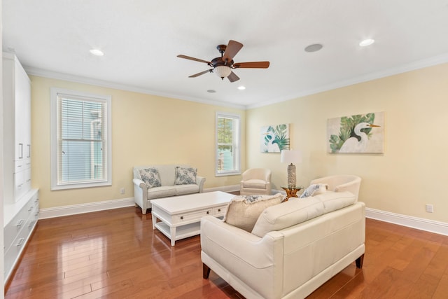 living room with wood-type flooring, ornamental molding, and a wealth of natural light