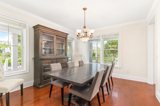 dining area with crown molding, dark hardwood / wood-style flooring, a healthy amount of sunlight, and a notable chandelier