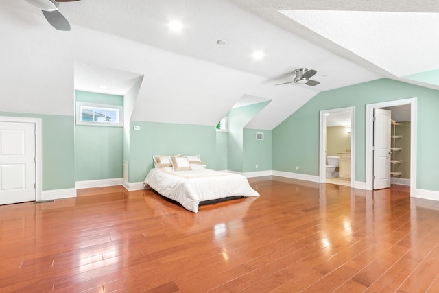 unfurnished bedroom featuring a textured ceiling, connected bathroom, hardwood / wood-style flooring, and ceiling fan