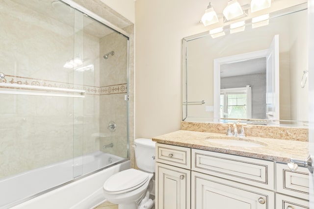 full bathroom featuring toilet, combined bath / shower with glass door, and vanity