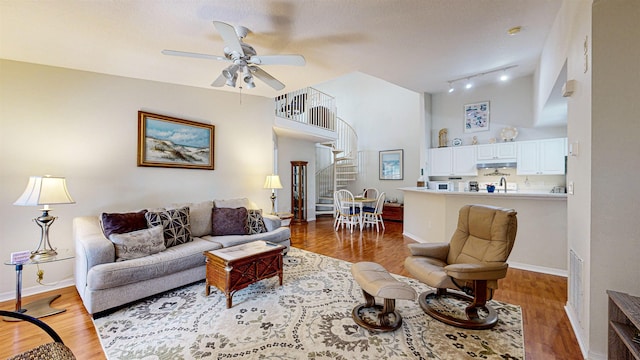 living room with dark hardwood / wood-style floors, ceiling fan, and rail lighting