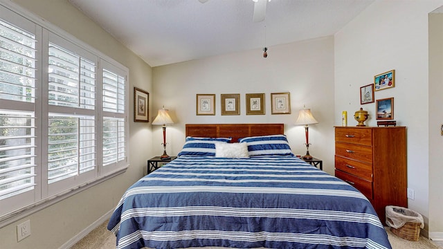 carpeted bedroom with ceiling fan and lofted ceiling