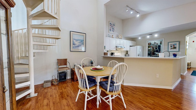 dining area with track lighting, light hardwood / wood-style floors, and sink