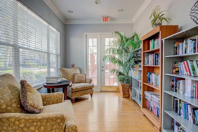 living area featuring light hardwood / wood-style floors and ornamental molding