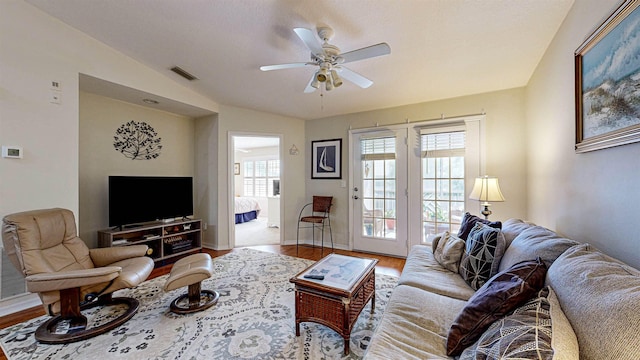 living room with hardwood / wood-style flooring, ceiling fan, and lofted ceiling