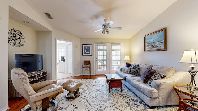 living room with ceiling fan, lofted ceiling, and light hardwood / wood-style flooring