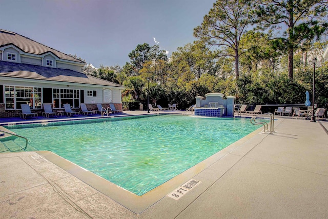 view of swimming pool featuring pool water feature and a patio area