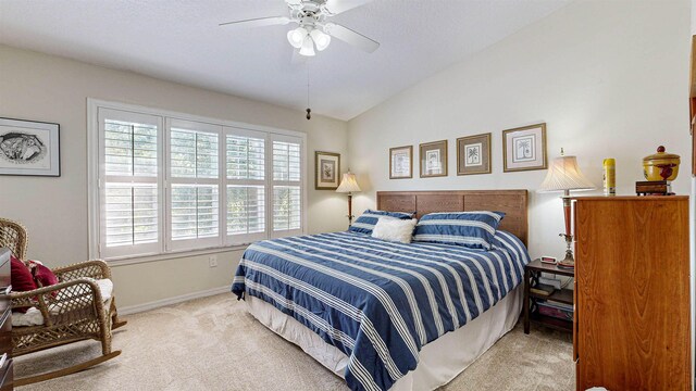 bedroom with ceiling fan, light carpet, and vaulted ceiling