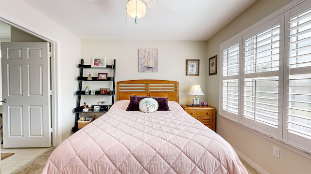 tiled bedroom featuring ceiling fan and a textured ceiling