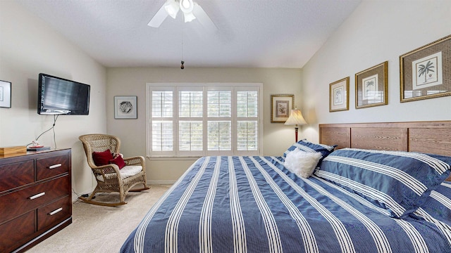 carpeted bedroom featuring ceiling fan, lofted ceiling, and a textured ceiling