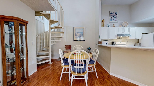 23213 Harbour Vista Cir, Saint Augustine, FL 32080 - dining space featuring baseboards, a high ceiling, and wood finished floors