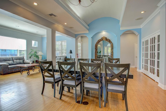 dining room with crown molding and light hardwood / wood-style floors