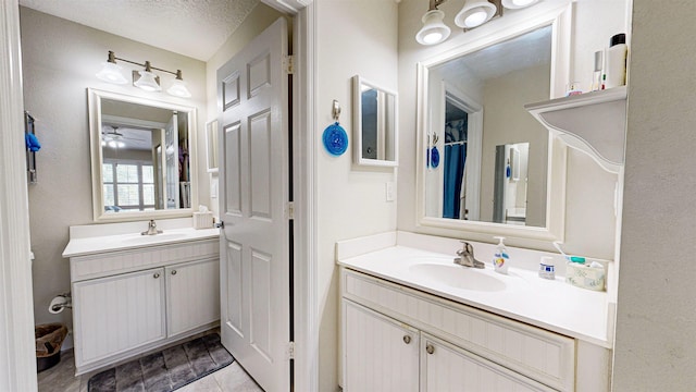 bathroom with ceiling fan, a textured ceiling, and vanity