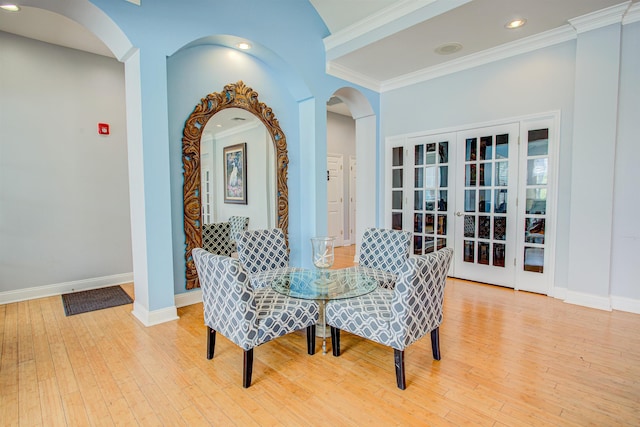 dining space with french doors, light hardwood / wood-style flooring, and crown molding