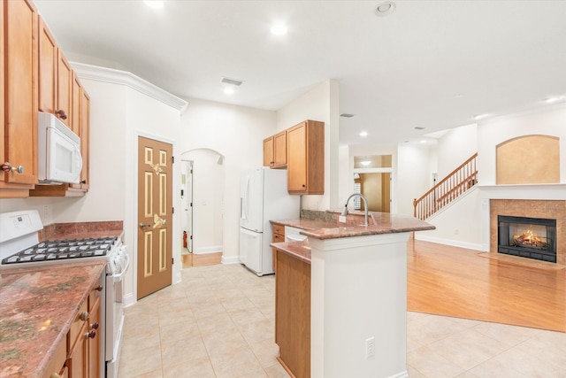 kitchen featuring light hardwood / wood-style floors, white appliances, and kitchen peninsula