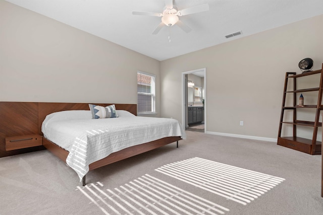 bedroom featuring ceiling fan, light colored carpet, and connected bathroom