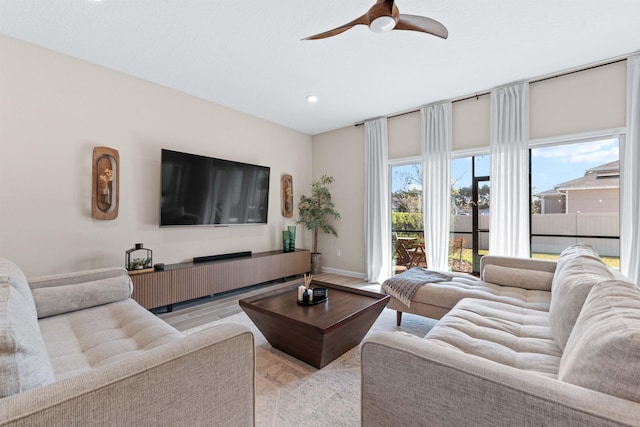 living room with ceiling fan and light hardwood / wood-style flooring