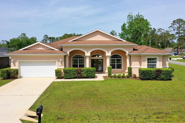 19 Ehrling Ln, Palm Coast, FL 32164 - view of front of house featuring stucco siding, a front yard, a garage, and driveway
