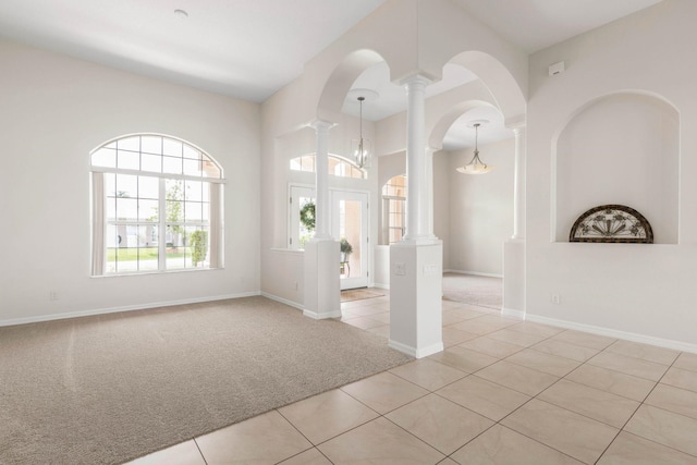 19 Ehrling Ln, Palm Coast, FL 32164 - empty room with light colored carpet, light tile patterned floors, decorative columns, baseboards, and arched walkways