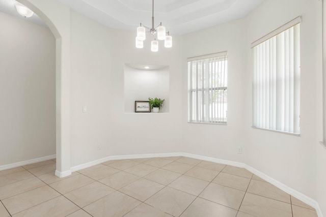 19 Ehrling Ln, Palm Coast, FL 32164 - spare room with light tile patterned floors, arched walkways, a chandelier, and baseboards