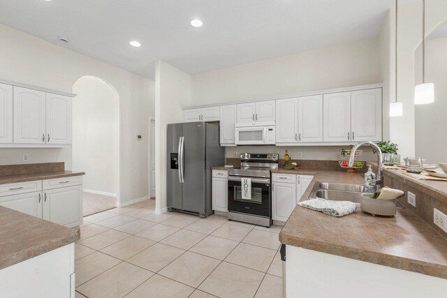 19 Ehrling Ln, Palm Coast, FL 32164 - kitchen with appliances with stainless steel finishes, arched walkways, a sink, white cabinetry, and recessed lighting