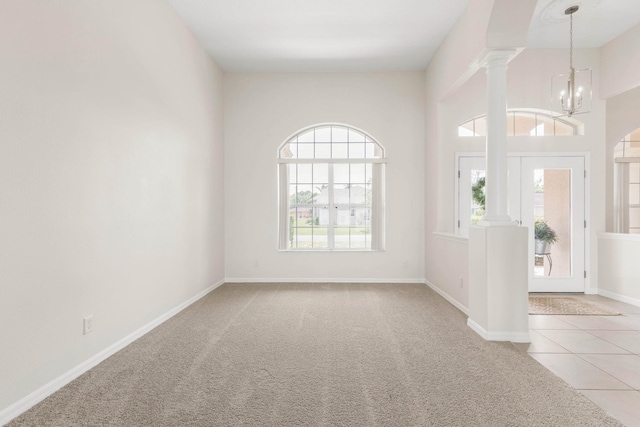 19 Ehrling Ln, Palm Coast, FL 32164 - carpeted entryway with decorative columns, a chandelier, baseboards, and tile patterned flooring