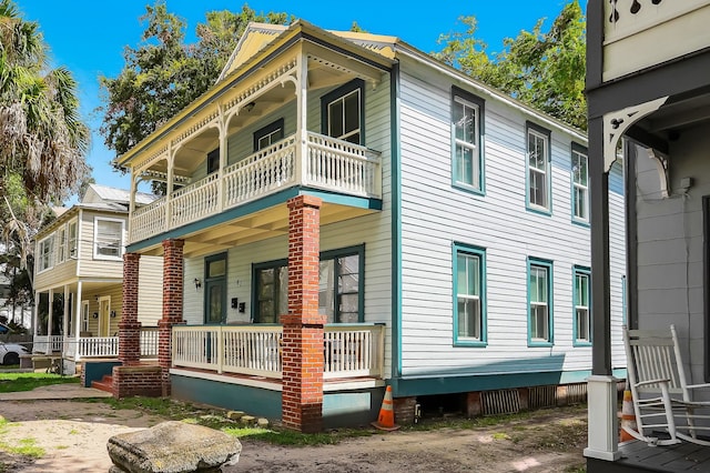 view of side of property featuring a porch and a balcony